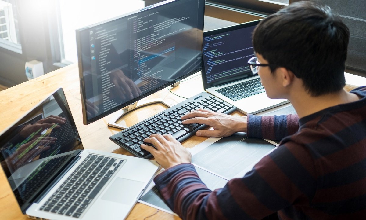 Pensive programmer working on on desktop pc programming code technologies or website design at office Software Development Company.